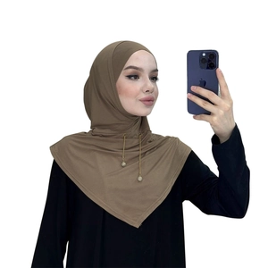 Vista dettagliata dell'elegante hijab marrone con delicate catenine d'oro e pendenti di perle.