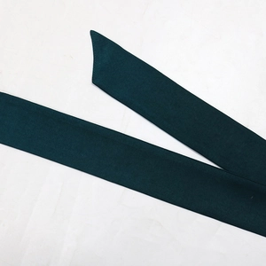 Detail of a dark green twill belt with diagonal cut end for long party dress gown