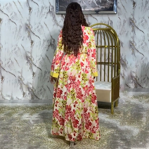 Detail view of long-sleeve floral maxi dress with vibrant red flowers and yellow cuffs