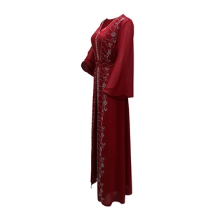 Dettaglio dell'abaya rossa in chiffon con ricami floreali in argento e scollatura a V