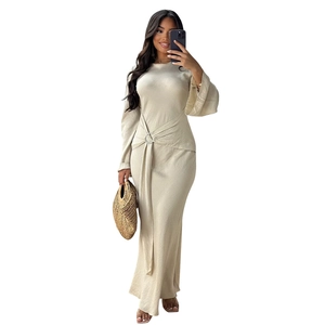 Detail of elegant champagne satin maxi dress featuring a waist metal ring and ruching