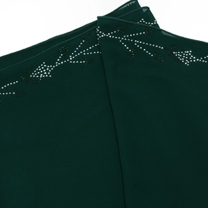 Detail of forest green chiffon robe with delicate white and green beaded leaf patterns