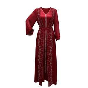 Dettaglio del ricamo in paillettes argento sul kaftano in chiffon rosso scuro a onde