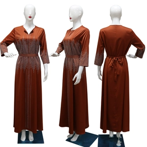 Détails de la robe de soirée en satin rouge brique avec strass brillants et ceinture