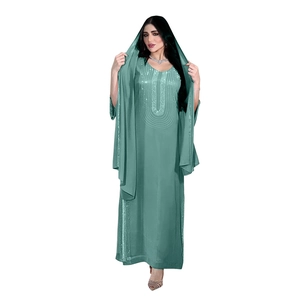 Dettaglio dell'abaya color petrolio con motivi di paillettes su scollo e maniche