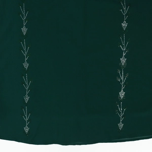 Detail view of dark green fabric dress featuring intricate vertical rhinestone floral patterns