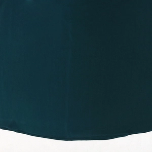 Detailed macro view of dark forest green matte fabric hem with fine stitching