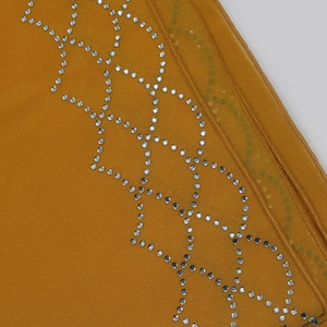 Macro view of mustard yellow chiffon fabric with intricate rhinestone diamond patterns