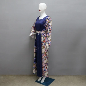 Dettaglio del maxi abito a fiori con giunzioni blu e bottoni decorativi in perle
