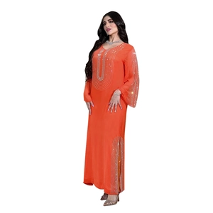 Dettaglio di abito arancione a maniche lunghe con strass scintillanti e spacchi laterali chic