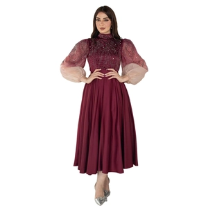 Detail of burgundy jalabiya dress with silver beadwork and gradient puff sleeves