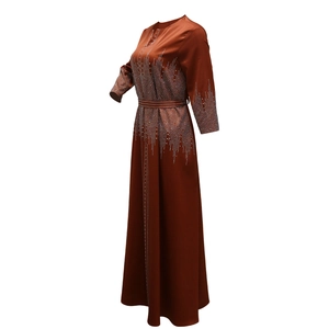 Détails de la robe en satin marron rouille avec strass scintillants sur les manches