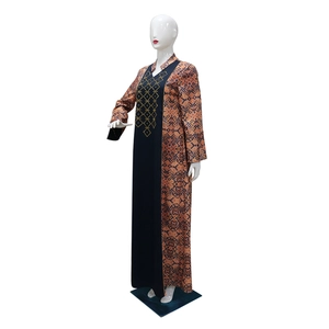 Detail of ethnic dress showing gold geometric embroidery and patterned contrast sleeves