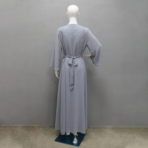 Dettaglio dell'abito abaya in chiffon grigio chiaro con cintura annodata sul retro e polsini