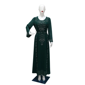 Detailed view of silver rhinestones and geometric patterns on a green maxi dress