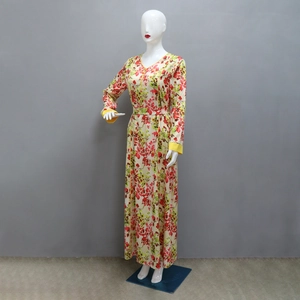 Detail of floral print maxi dress featuring a V-neck and yellow decorative cuffs