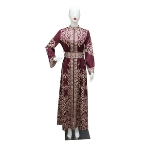 Detailed pattern of a burgundy jalabiya dress with golden floral prints on a mannequin