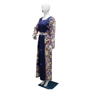 Dettaglio del motivo floreale patchwork e bottoni decorativi bianchi su un abito lungo blu