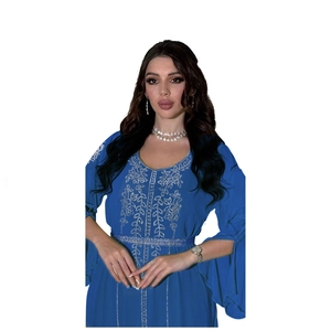 Close-up of blue kaftan dress with silver floral embroidery and split bell sleeves