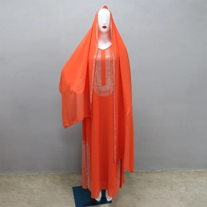 Dettaglio degli strass argentati sulla scollatura di un abito abaya arancione etnico