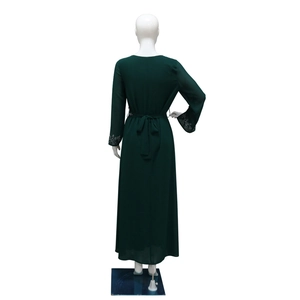 Detail view of the forest green long-sleeve dress with silver sequins on the cuffs
