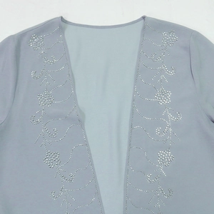 Dettaglio del cardigan in chiffon lilla con ricamo floreale in strass argentati