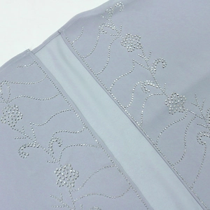 Vista macro di un abito in chiffon lavanda con ricamo floreale in strass argentati