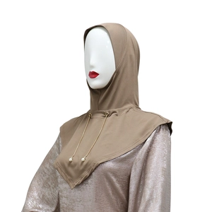 Primo piano del hijab kaki con eleganti catenelle di perle e dettagli dorati raffinati.