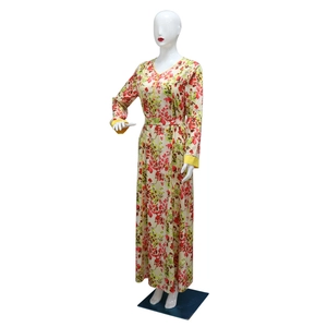 Detail of floral print dress with yellow satin trim and bohemian pattern on beige fabric