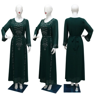 Detail of dark green kaftan dress featuring elegant silver rhinestone patterns on sleeves