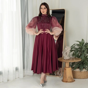 Detailed view of burgundy jalabiya dress with sequined puffy mesh sleeves and crystals