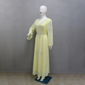 Close-up of silver rhinestones and sequins on a light yellow chiffon maxi dress