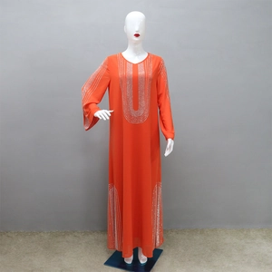 Dettaglio dei motivi in strass argentati su un abito Abaya arancione a maniche lunghe