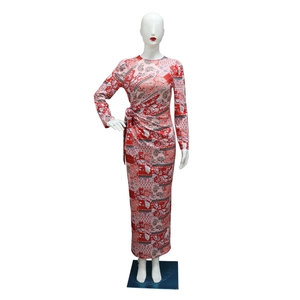 Close-up of ankle-length long sleeve dress featuring red paisley floral print and waist knot