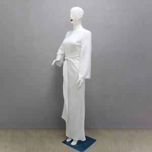 Detailed side view of white maxi dress featuring waist pleats and metal ring ornament