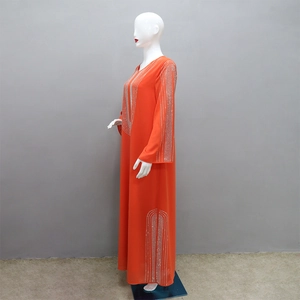Dettaglio dell'abito abaya arancione a maniche lunghe con motivi geometrici in strass