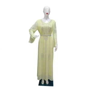 Close-up of silver rhinestone floral patterns on light yellow chiffon abaya dress