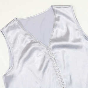 Dettaglio del top in raso argento con scollo a V e decorazioni in strass eleganti