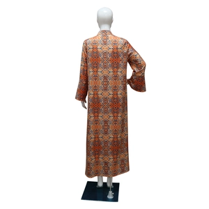 Back view of long ethnic robe with orange and blue geometric patterns on a mannequin
