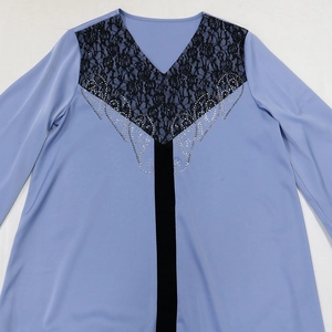 Detail showing V-neck design with black lace patchwork and rhinestone floral patterns