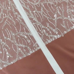 Detail of satin dress with pink fabric and silver sequin embroidery in a branch pattern