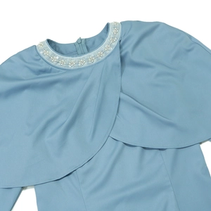 Détail de la broderie de perles et de paillettes sur le col châle bleu clair de la robe