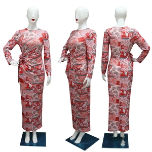 Detail view of long-sleeved dress with red paisley floral pattern and side pleats