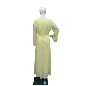 Detail of light yellow chiffon dress featuring silver rhinestone embroidery on sleeves