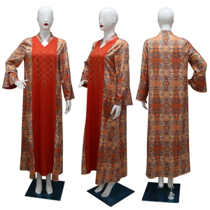 Detailed view of women's long robe with ethnic geometric patterns and gold rivet design