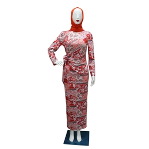 Detail of floral paisley print on long sleeve Muslim dress with red hijab accessory