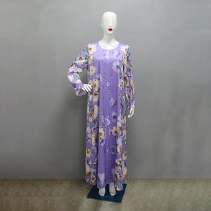 Dettaglio dell'abito maxi a fiori viola con pieghe frontali e bottoni di perle bianche