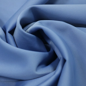 Macro shot of smooth blue velvet and lace fabric with elegant satin sheen and soft drapes