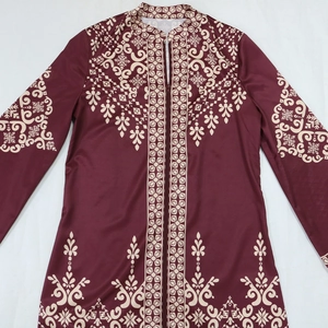 Detail of burgundy jalabiya dress featuring intricate white floral prints and zipper closure