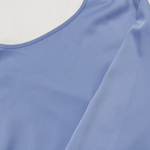 Detail view of light blue dress showing the round neckline with fine stitching craftsmanship